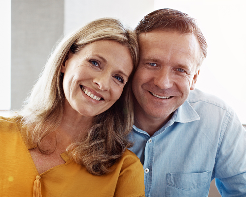 Man and woman with dental implants in London smiling