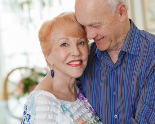 man and woman close together smiling after receiving dental implants in London