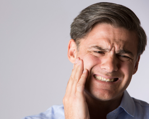 man touching his cheek in need of a root canal