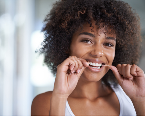 woman with gum disease flossing her teeth - gum disease clapham, London