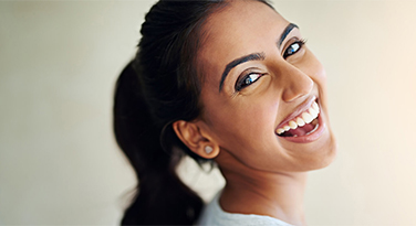 A beautiful woman looking over her shoulder and smiling at the camera