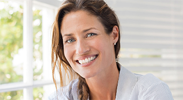 A middle aged woman with a beautiful smile looking at the camera