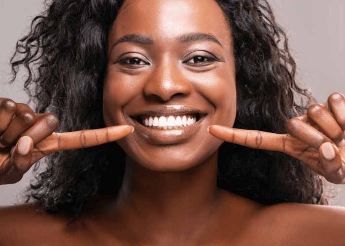 woman pointing at her teeth with periodontal disease in London