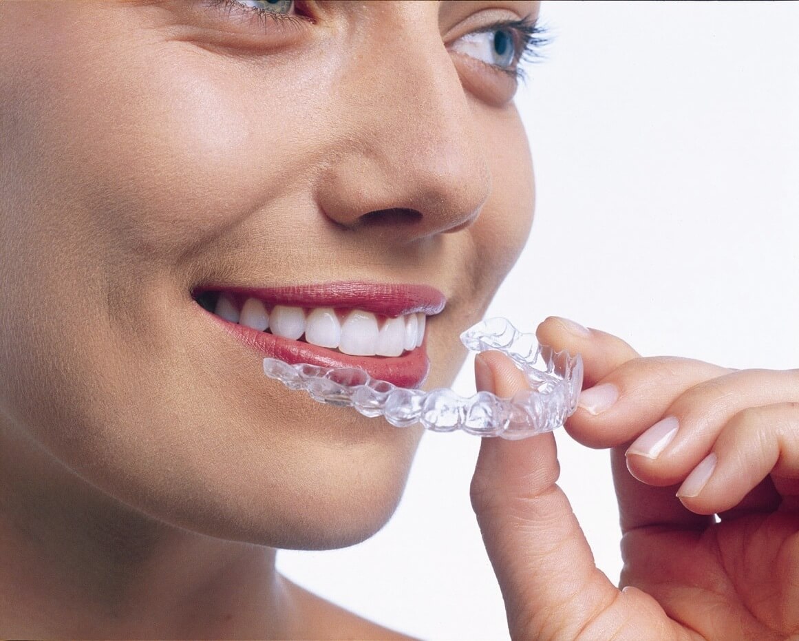 Woman putting in Invisalign braces at CLDP